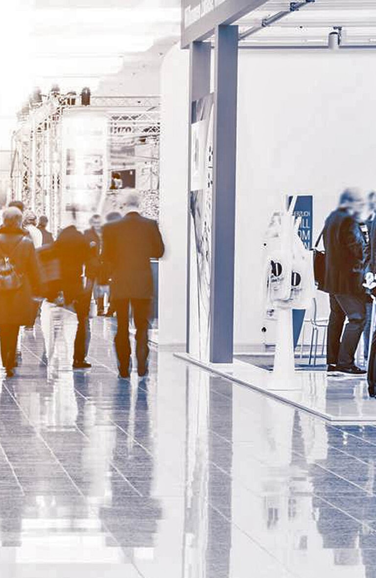 Messehalle mit Ständen und Besuchern