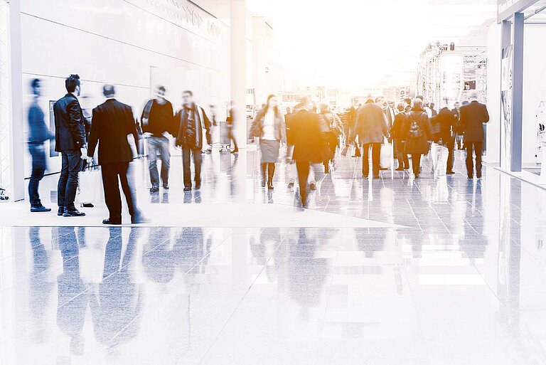Messehalle mit Ständen und Besuchern